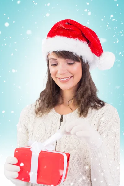 Festive brunette opening a gift — Stock Photo, Image