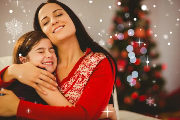 Madre e hija festiva abrazándose en el sofá — Foto de Stock