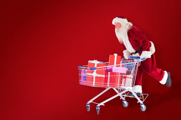 Santa empuja un carrito de compras — Foto de Stock