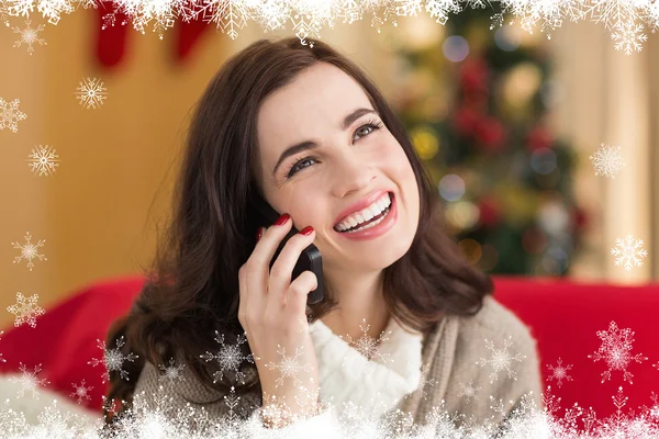 Smiling brunette on the phone on christmas — Stock Photo, Image