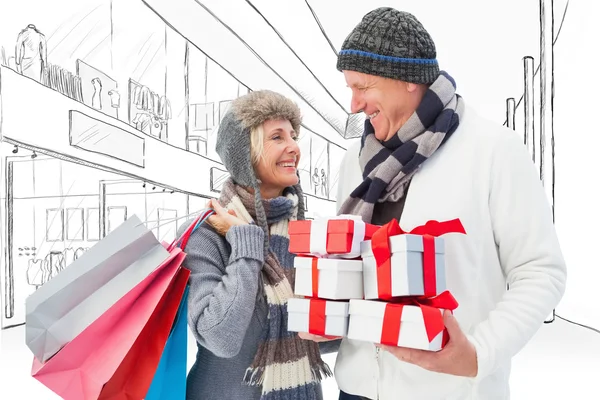 Festive mature couple holding christmas gifts — Stock Photo, Image