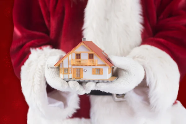 Santa houdt een klein huisje — Stockfoto