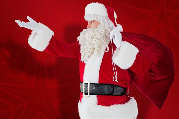 Immagine composita di Babbo Natale con mano fuori e tenendo sacco — Foto Stock
