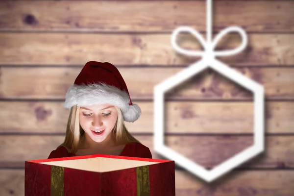 Composite image of festive blonde holding a gift — Stock Photo, Image