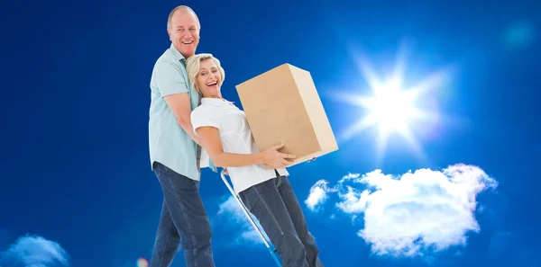 Fun older couple holding moving boxes — Stock Photo, Image
