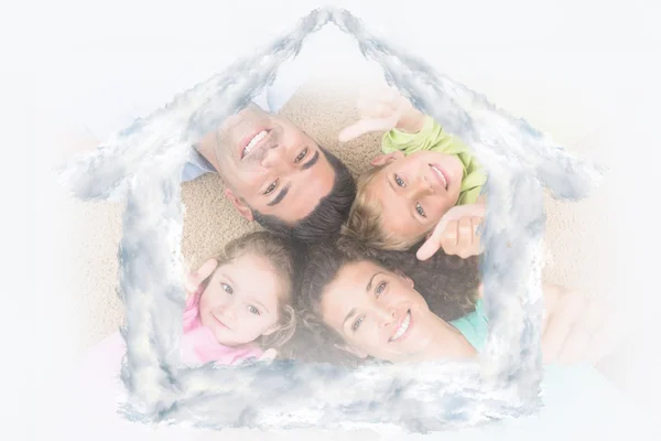 Smiling family lying on the rug in a circle — Stock Photo, Image