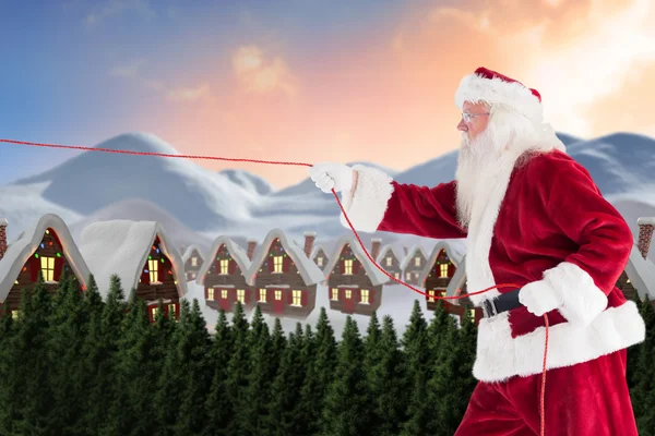 Santa drar något med rep — Stockfoto