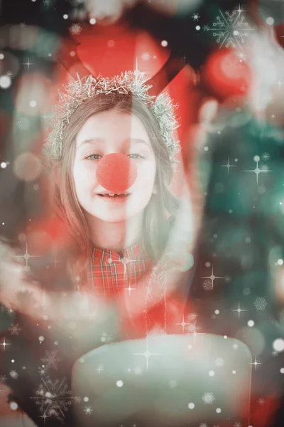 Menina festiva vestindo nariz vermelho — Fotografia de Stock