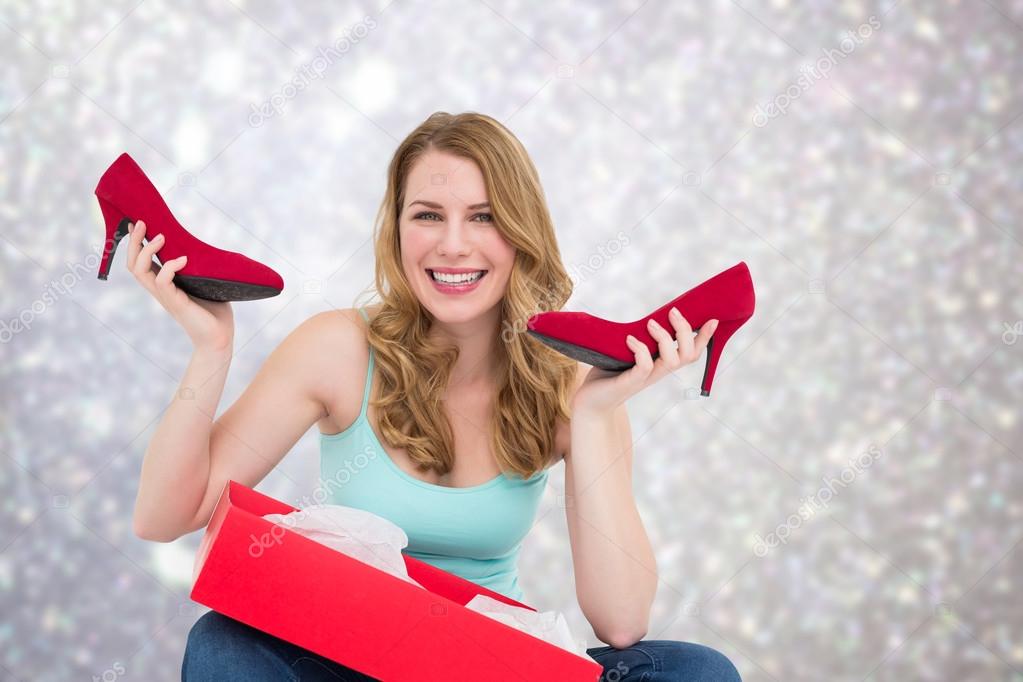 Composite image of smiling woman holding up her new shoes Stock Photo ...