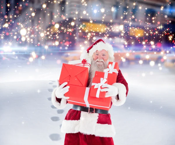 Santa hediyeler karda taşıyan — Stok fotoğraf