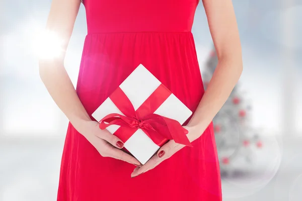 Vrouw in rode jurk bedrijf geschenk — Stockfoto