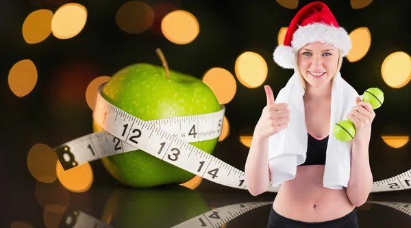 Composite image of festive fit blonde smiling at camera — Stock Photo, Image