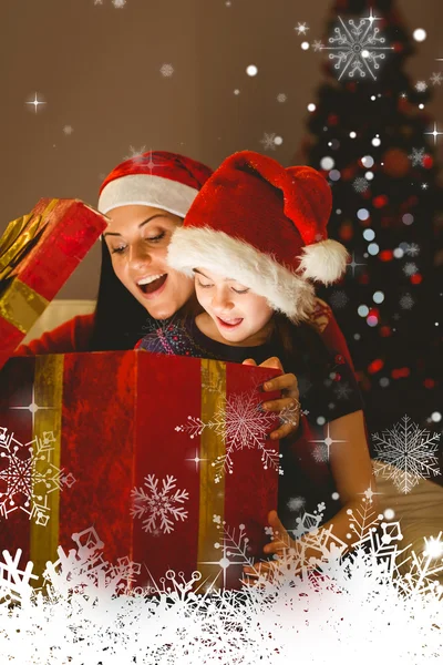 Mãe e filha festiva abrindo um Natal — Fotografia de Stock