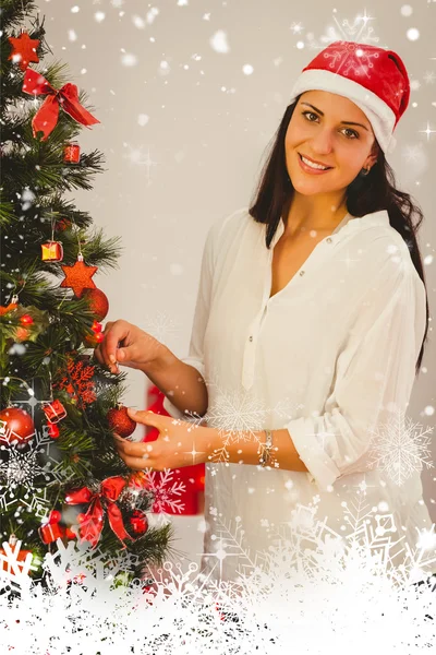 Woman hanging christmas decorations on tree — Stock Photo, Image