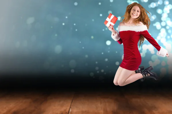 Festive redhead jumping with gift — Stock Photo, Image