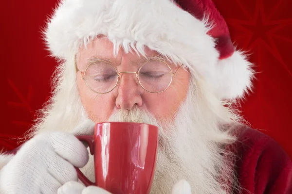 Санта пьет из красной чашки — стоковое фото