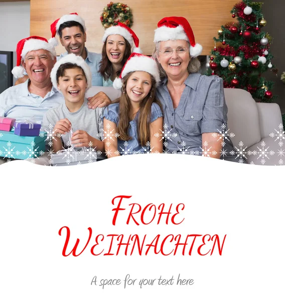 Extended family in christmas hats with gift — Stock Photo, Image
