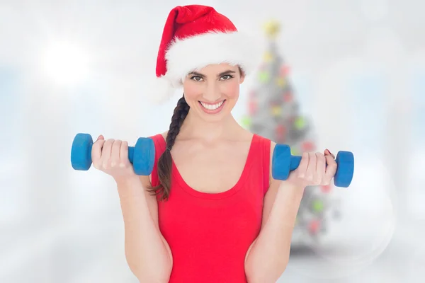 Festive fit brunette holding dumbbells — Stock Photo, Image