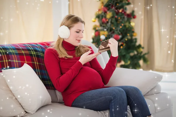 Pregnant woman looking at baby shoes — Stock Photo, Image