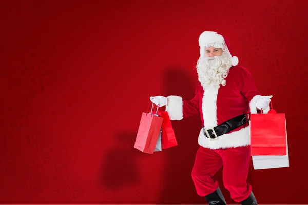 Lachende santa claus houden shopping tassen — Stockfoto