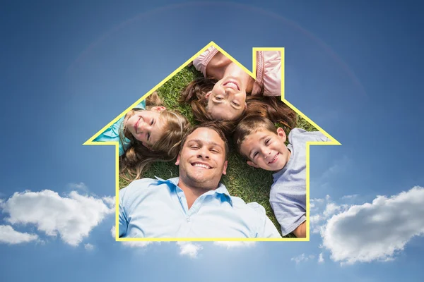 Liggend op het gras in een cirkel en gelukkige familie — Stockfoto