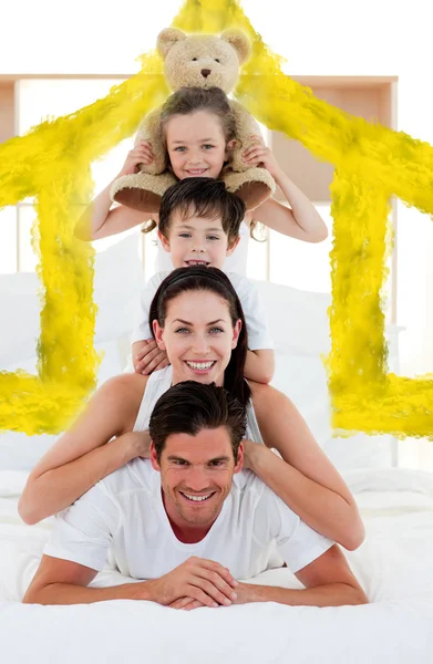 Young family playing on bed together — Stock Photo, Image