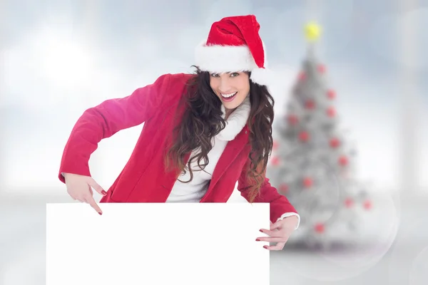 Festive brunette pointing white poster — Stock Photo, Image