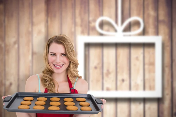 Femme souriante montrant des cookies chauds — Photo