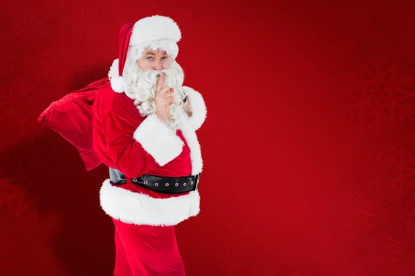Santa hält ein Geheimnis und hält seinen Sack — Stockfoto