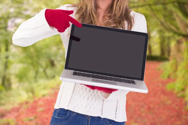 Feestelijke blonde wijzend op laptop — Stockfoto