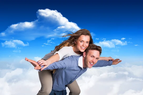 Smiling young man carrying woman — Stock Photo, Image