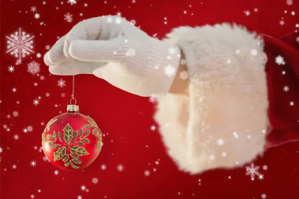 Santas hand is holding a Christmas bulb — Stock Photo, Image