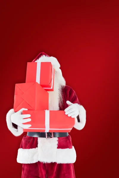 Santa se týká jeho tvář s dárky — Stock fotografie