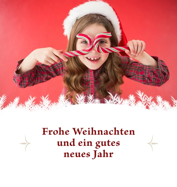 Mädchen mit Weihnachtsmütze und Zuckerstangen — Stockfoto