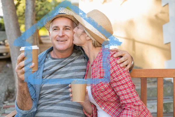 Happy mature couple drinking coffee on a bench — Stock Photo, Image