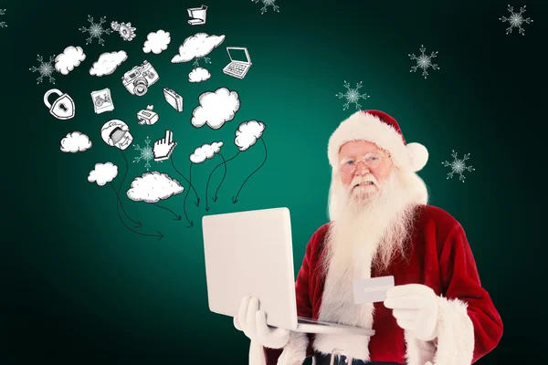 Weihnachtsmann bezahlt mit Kreditkarte am Laptop — Stockfoto