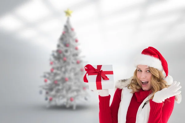 Eccitato bionda in cappello di Babbo Natale in possesso di regalo — Foto Stock