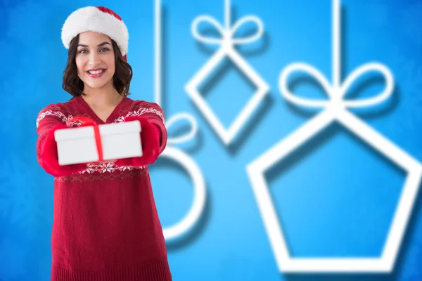 Imagen compuesta de morena sonriente en guantes rojos sosteniendo regalo — Foto de Stock