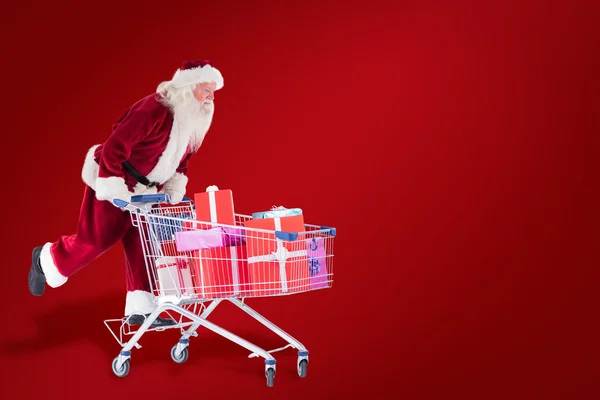 Santa duwt een winkelwagentje — Stockfoto