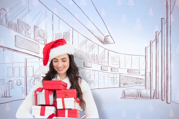 Festive brunette holding pile of gifts — Stock Photo, Image