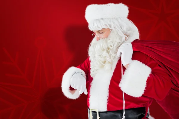 Festlicher Weihnachtsmann kontrolliert die Uhrzeit — Stockfoto