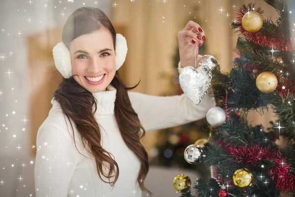 Sorrindo morena segurando uma bugiganga no Natal — Fotografia de Stock