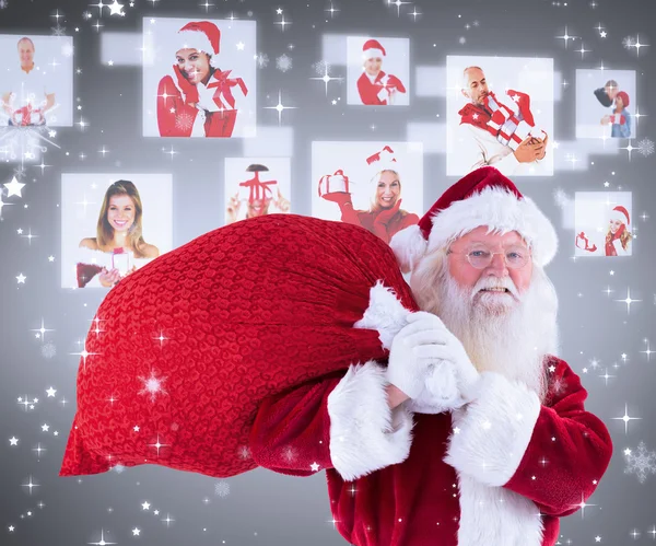 Santa draagt zijn rode zak en glimlacht — Stockfoto