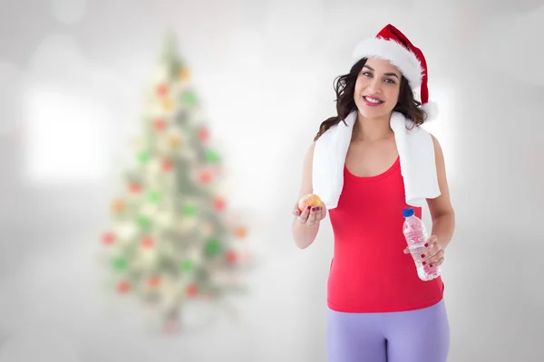 Composite image of festive fit brunette smiling at camera — Stock Photo, Image