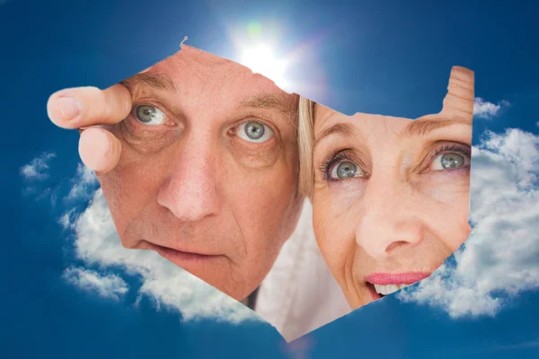 Older couple looking through rip — Stock Photo, Image