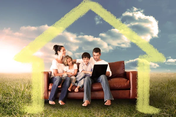 Happy family using the laptop in a field — Stock Photo, Image