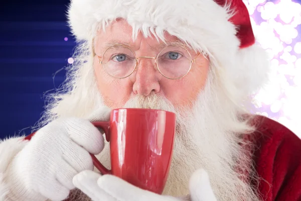 Santa drycker från röd kopp — Stockfoto