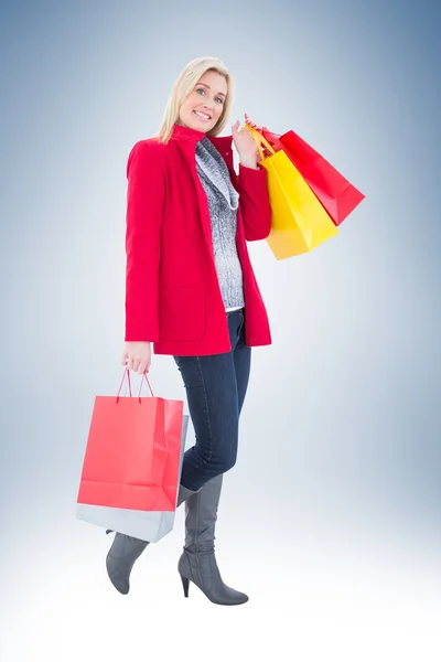 Gelukkig blonde bedrijf shopping tassen — Stockfoto