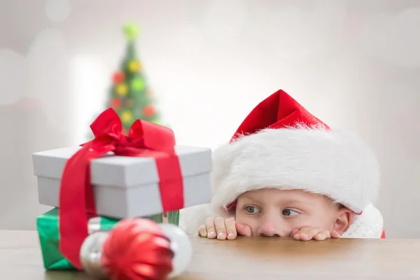 Composite image of cute boy looking at gifts — Stock Photo, Image