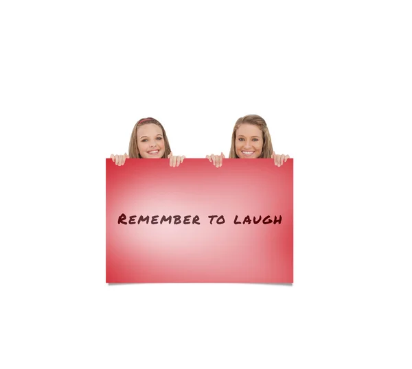 Composite image of close up of young women behind a blank sign — Stock Photo, Image